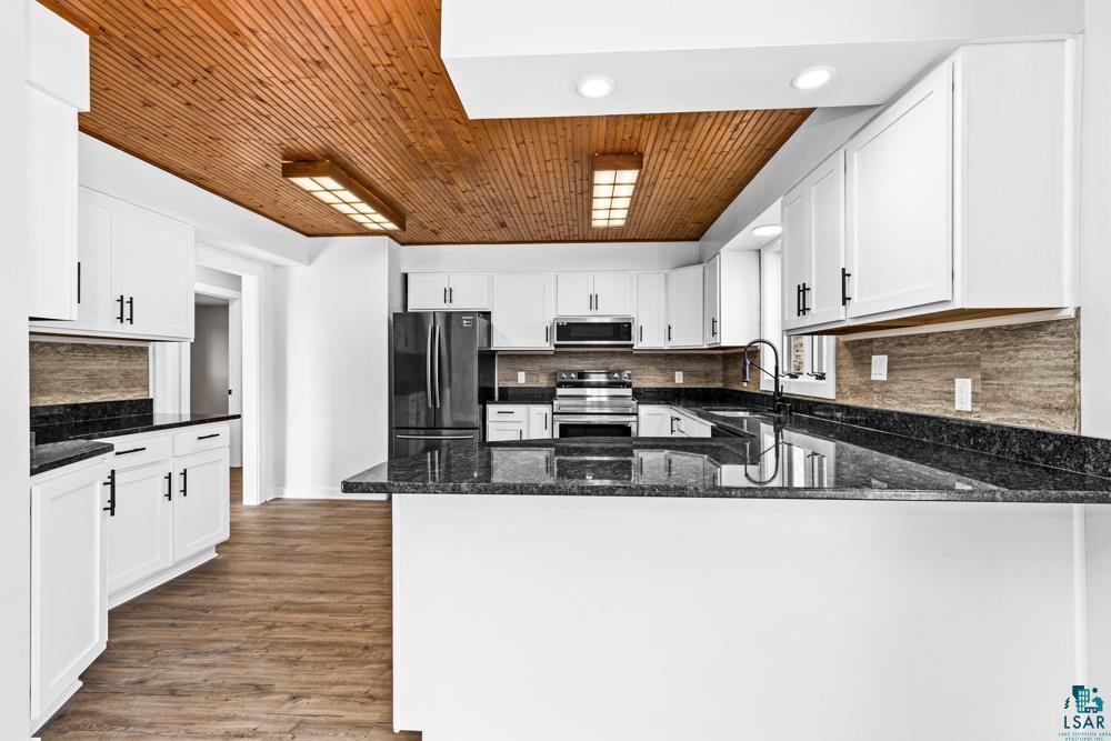 1148 Shoreview Road Two Harbors, MN 55616 - Photo 13 of 48 Kitchen featuring kitchen peninsula, stainless steel appliances, and white cabinets