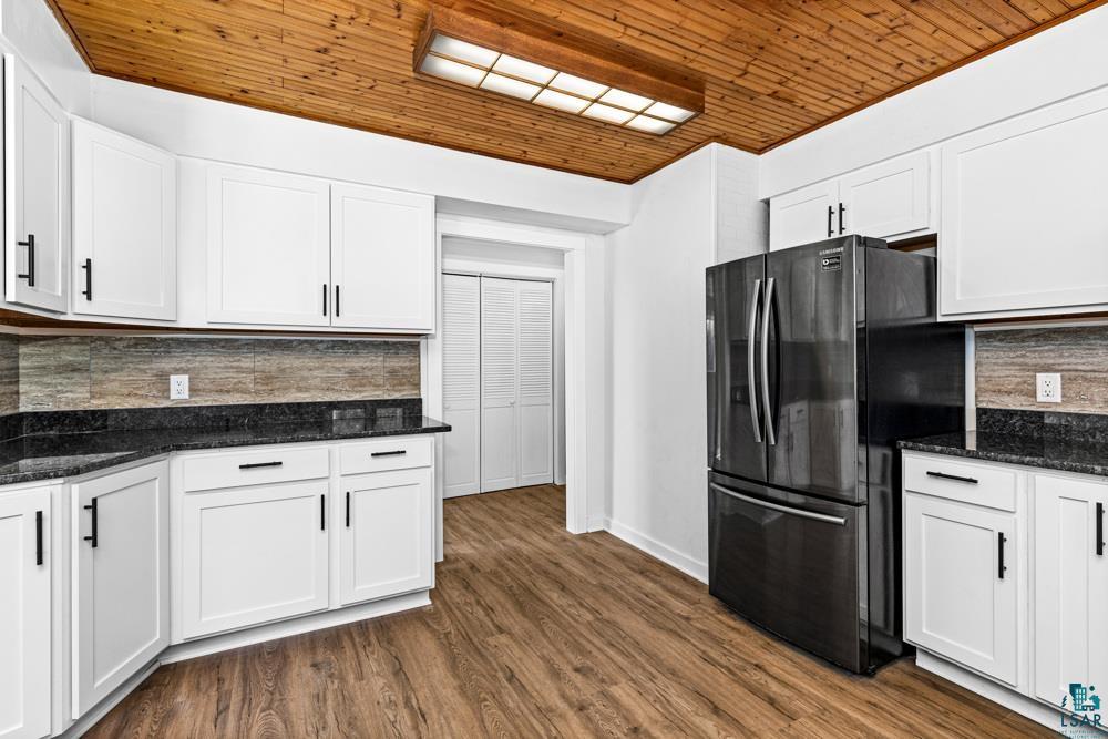 1148 Shoreview Road Two Harbors, MN 55616 - Photo 16 of 48 Kitchen with backsplash, white cabinetry, stainless steel refrigerator, and dark wood-type flooring