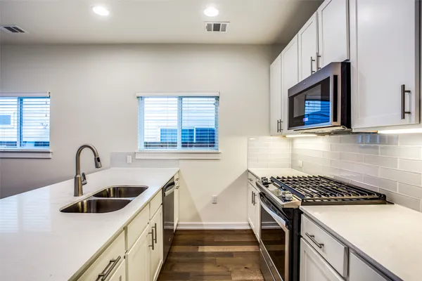a kitchen with a sink a stove and cabinets