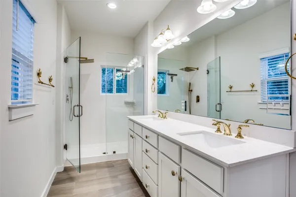 a bathroom with a sink vanity granite shower and a mirror