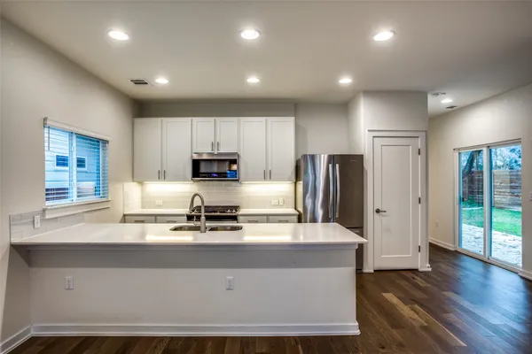 a kitchen with kitchen island white cabinets and stainless steel appliances
