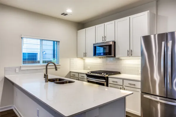a kitchen with a refrigerator stove and sink