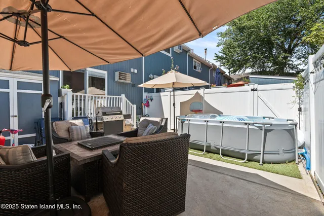 a view of a patio with table and chairs under an umbrella