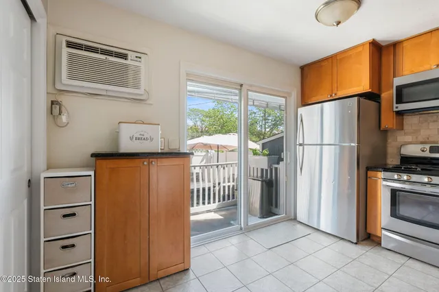 a view of kitchen with furniture refrigerator and window