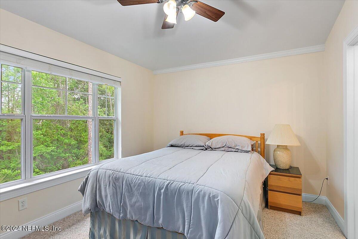 160 Legendary Drive, Unit 206 St. Augustine, FL 32092 - Photo 11 of 20 a bedroom with a bed and a chandelier