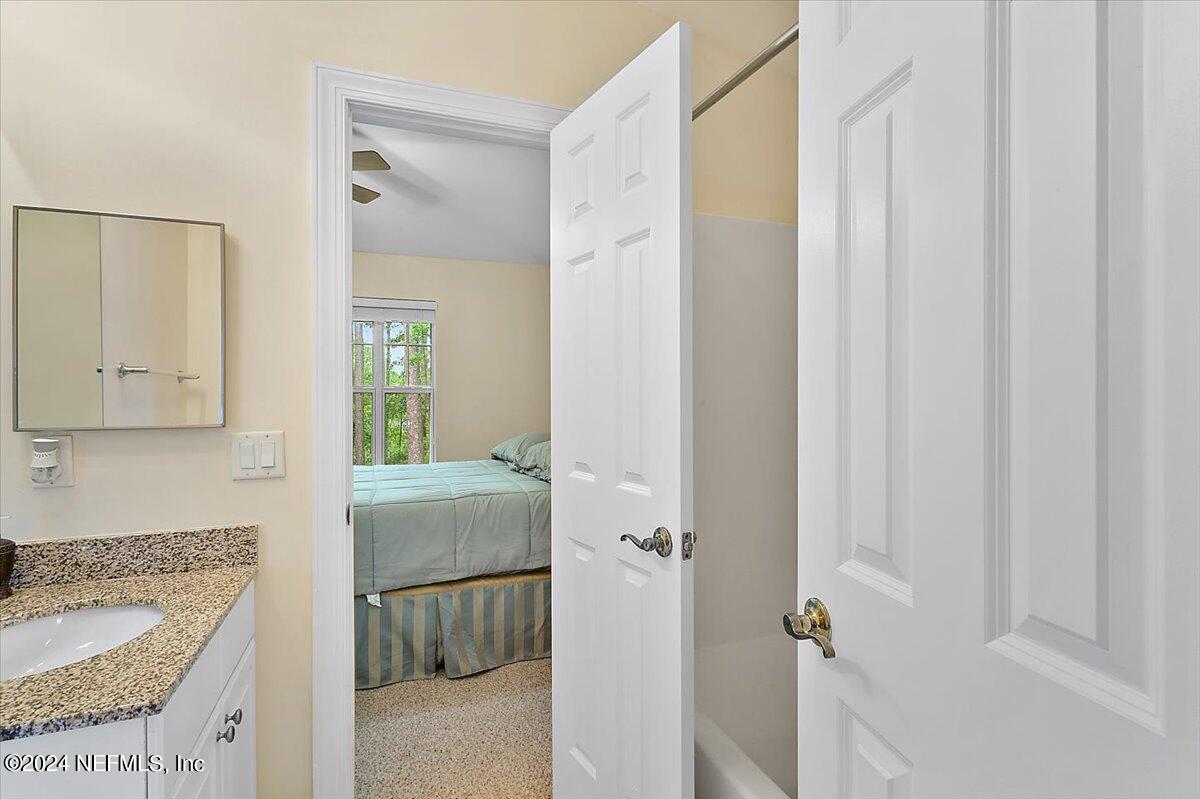 160 Legendary Drive, Unit 206 St. Augustine, FL 32092 - Photo 13 of 20 a bathroom with a granite countertop sink and a mirror