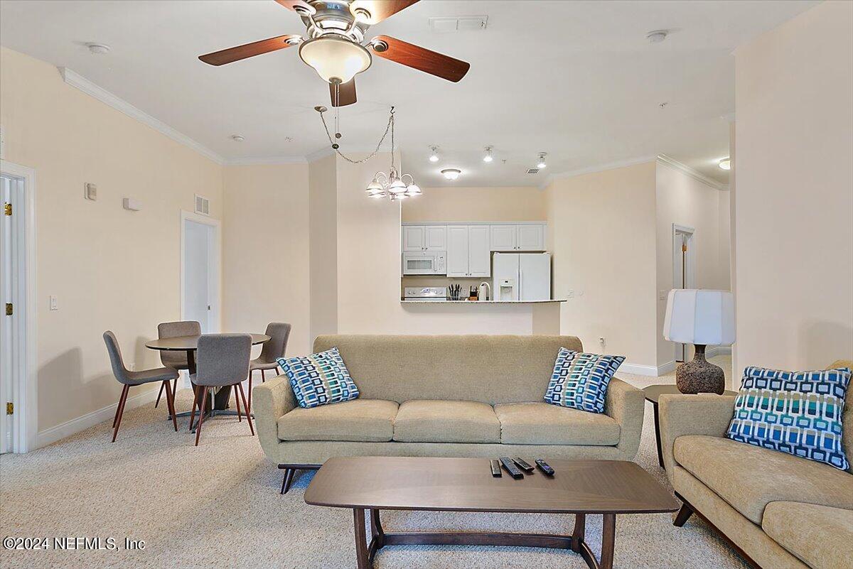160 Legendary Drive, Unit 206 St. Augustine, FL 32092 - Photo 4 of 20 a living room with furniture and a chandelier