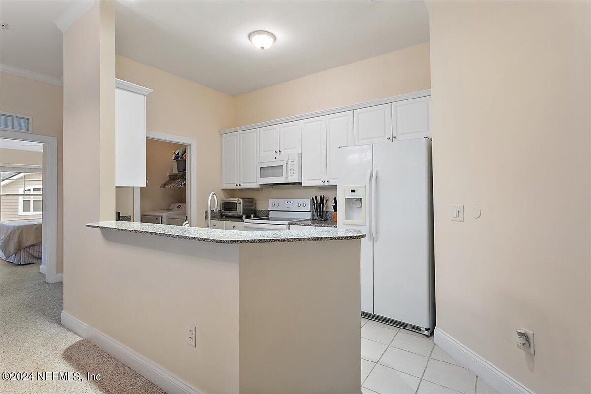 160 Legendary Drive, Unit 206 St. Augustine, FL 32092 - Photo 6 of 20 a kitchen with stainless steel appliances granite countertop a refrigerator sink and cabinets