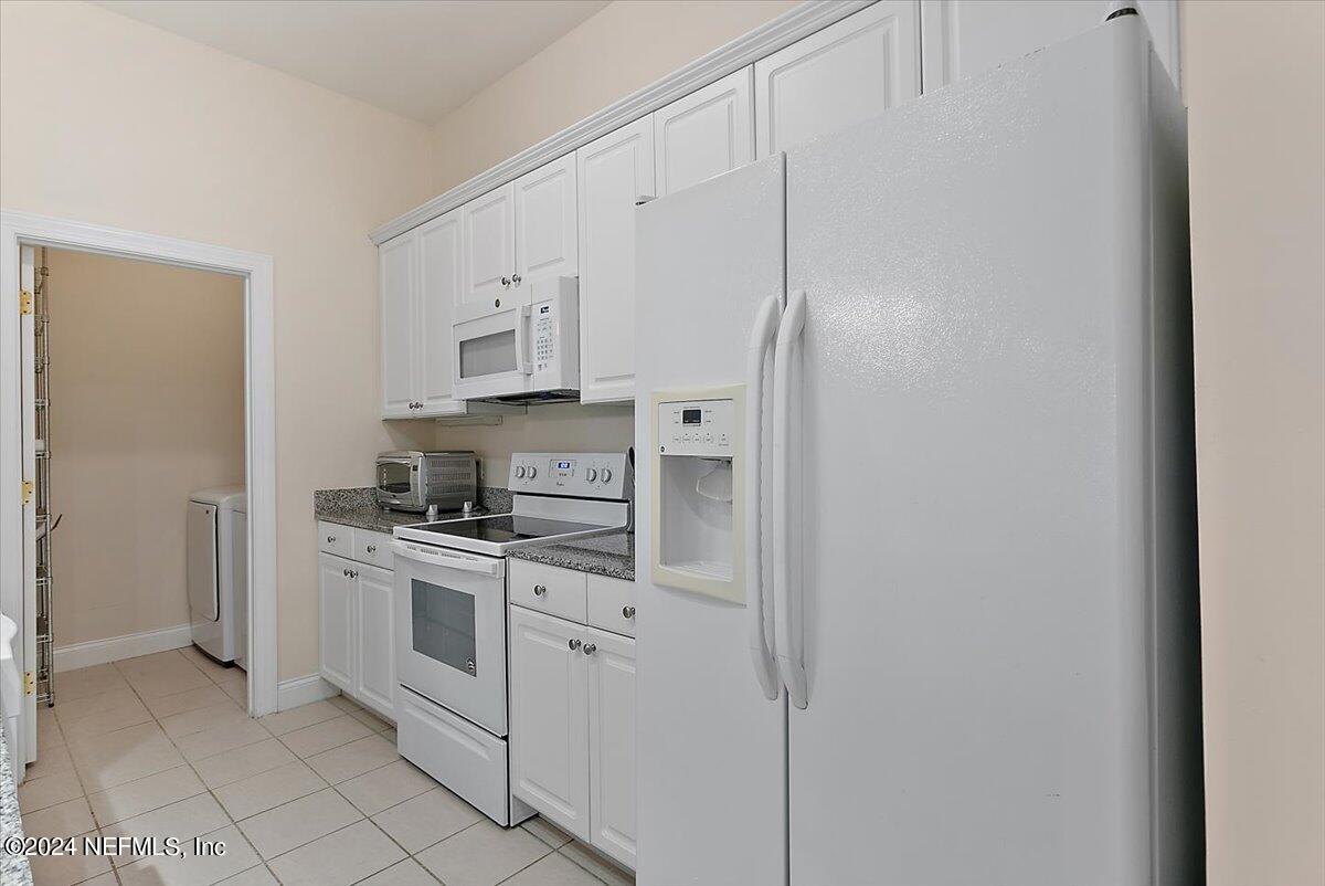 160 Legendary Drive, Unit 206 St. Augustine, FL 32092 - Photo 7 of 20 a kitchen with white cabinets and stainless steel appliances