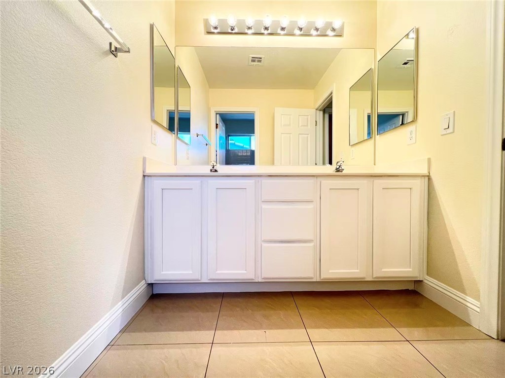 9891 Ridge Hill Avenue Las Vegas, NV 89147 - Photo 25 of 29 Double vanity with ample storage and sleek tile flooring perfect for daily routines.