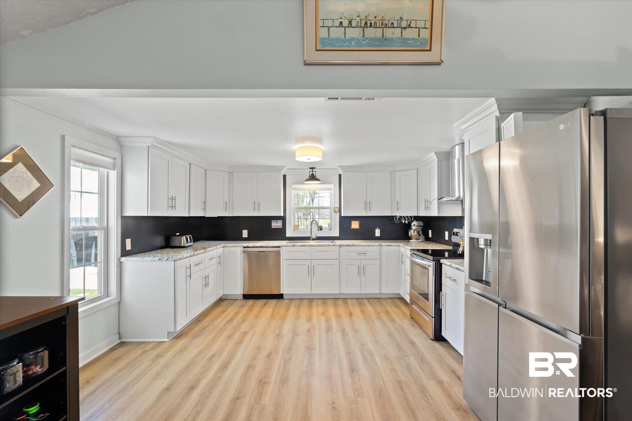14280 Cat Deakle Road Grand Bay, AL 36541 - Photo 11 of 51 Kitchen featuring appliances with stainless steel finishes, white cabinetry, a sink, and decorative backsplash