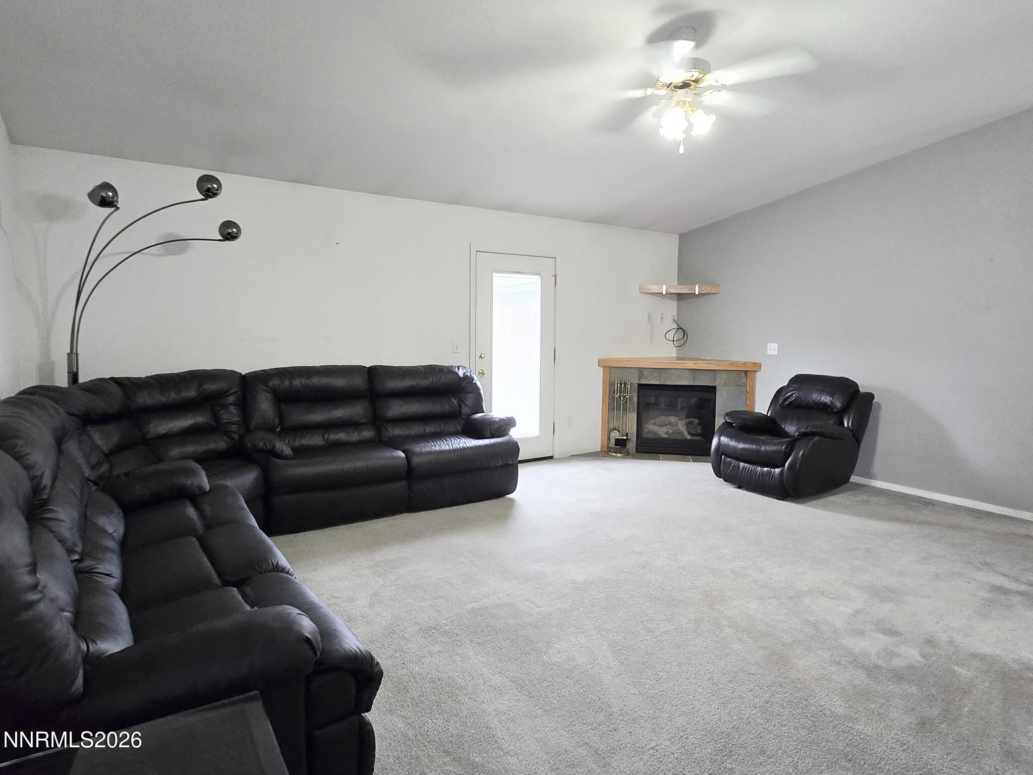 476 Jennys Lane Fernley, NV 89408 - Photo 5 of 29 a living room with furniture a ceiling fan and a fireplace
