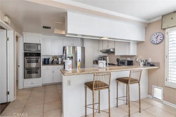 a kitchen with cabinets stainless steel appliances and a counter space