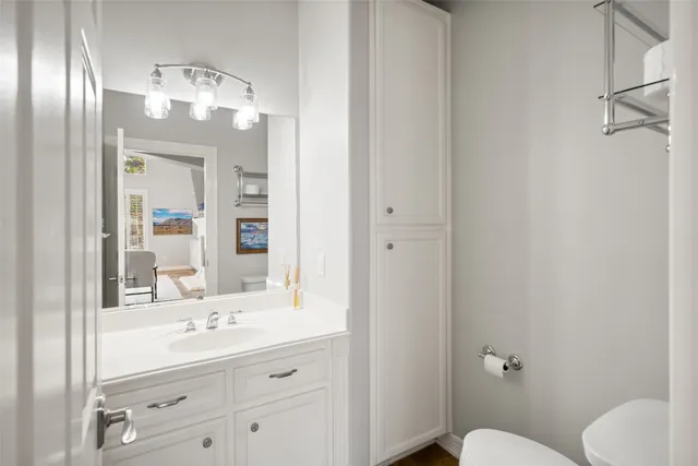 a bathroom with a sink vanity mirror and toilet