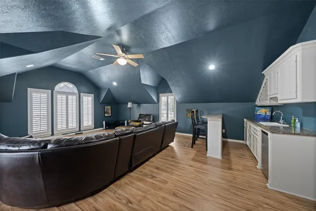 a large kitchen with stainless steel appliances wooden floors and a view of living room