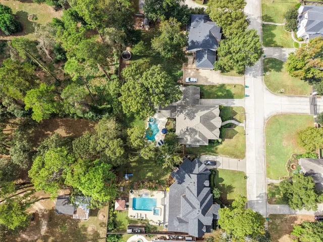 an aerial view of residential house with outdoor space and trees all around