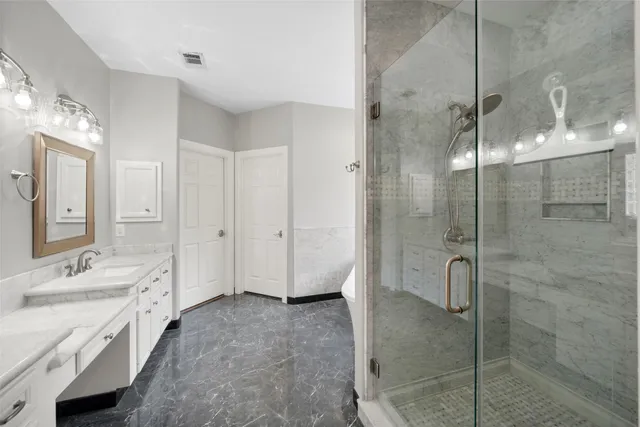 a spacious bathroom with a shower sink and mirror