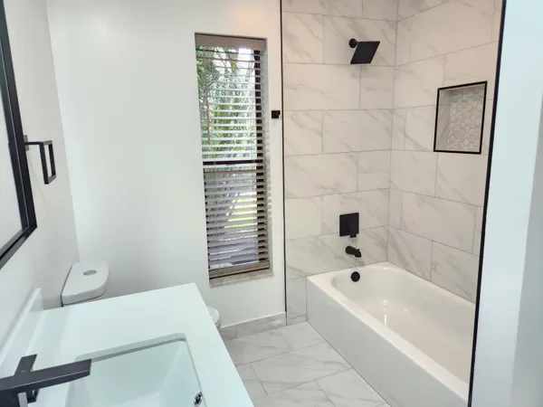 a bathroom with a toilet a sink a vanity and mirror