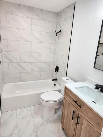 a bathroom with a bathtub a toilet a sink and a shower