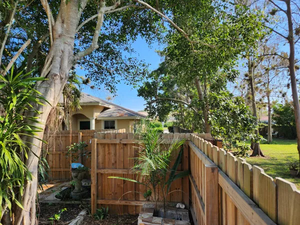 a backyard of a house with garden and outdoor seating