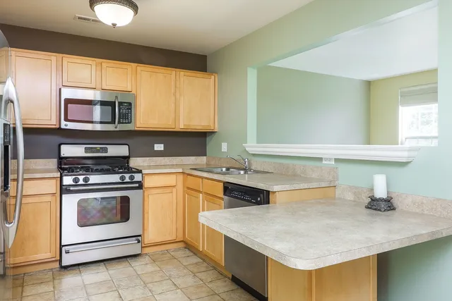 a kitchen with stainless steel appliances granite countertop a sink and a stove