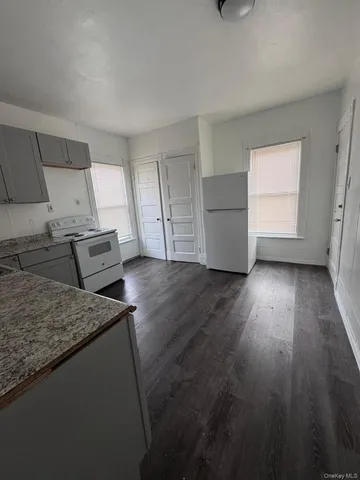 a kitchen with granite countertop wooden floors and wide window