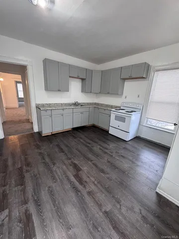 a living room with furniture and hard wood flooring
