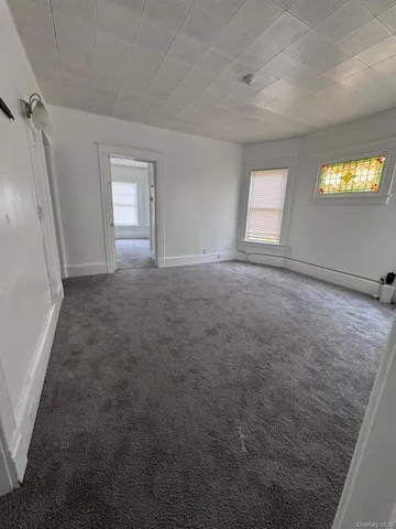 an empty room with windows and mirror