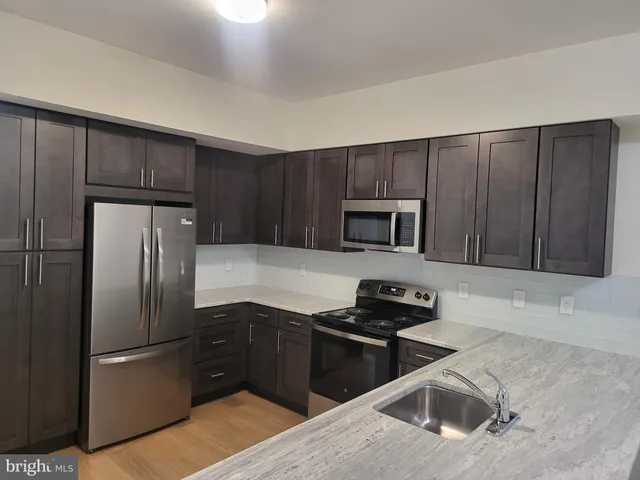 a kitchen with wooden cabinets and stainless steel appliances