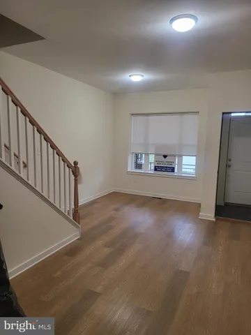 a view of a hallway with wooden floor and stairs