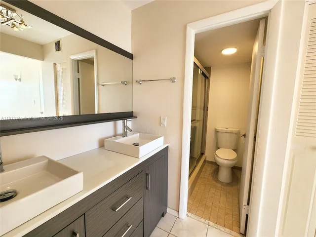 a bathroom with a sink a toilet and a mirror