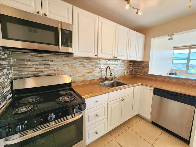 a kitchen with stainless steel appliances a stove a microwave sink and cabinets