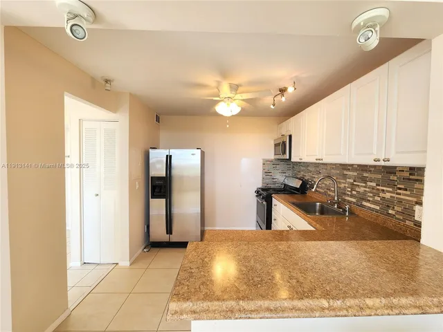 a kitchen with kitchen island granite countertop a stove a sink and a refrigerator