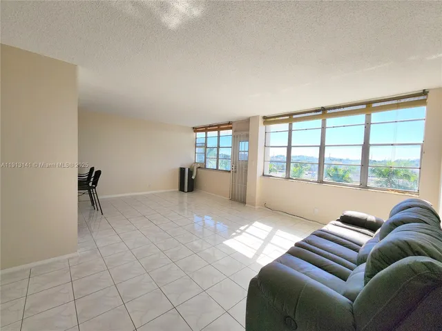 a living room with furniture and large windows