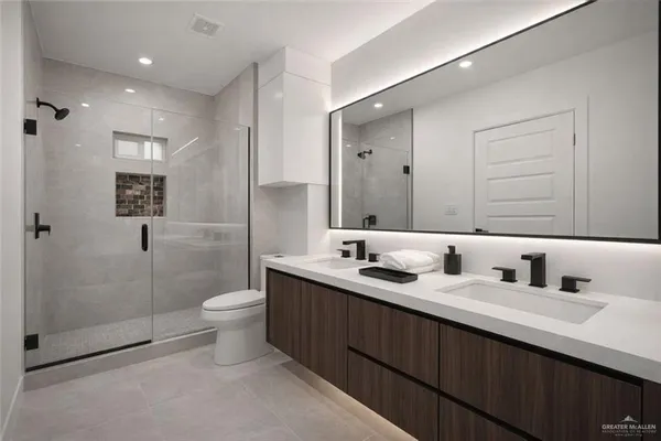 a bathroom with a double vanity sink toilet and shower