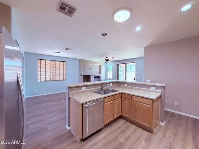 a kitchen with a sink and wooden floor