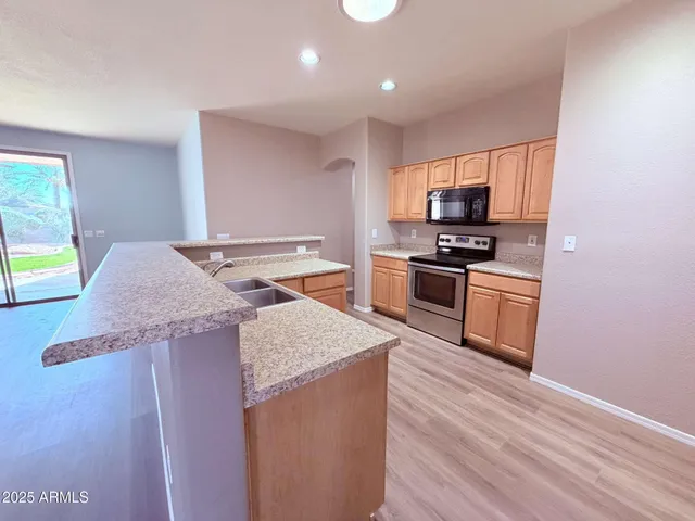 a kitchen with stainless steel appliances granite countertop a sink stove and refrigerator