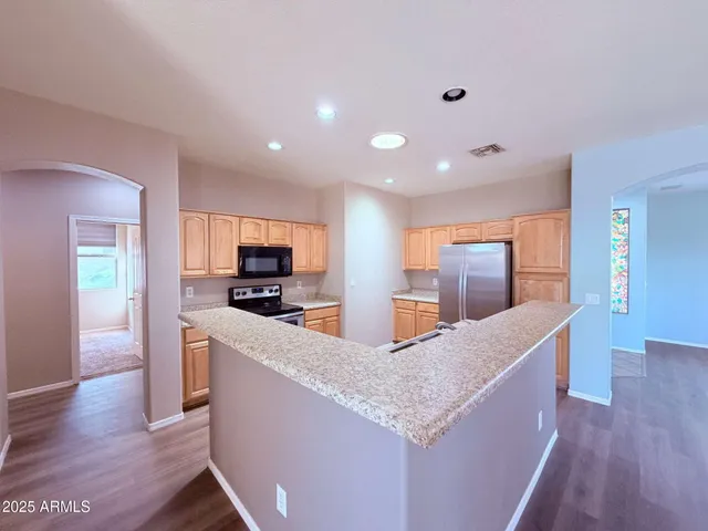 a kitchen with stainless steel appliances granite countertop a refrigerator a sink and a stove
