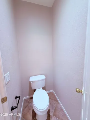 a white toilet sitting next to a white wall