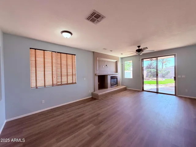 an empty room with wooden floor and a fireplace