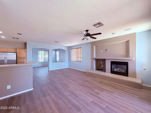 a view of an empty room with a fireplace and a window