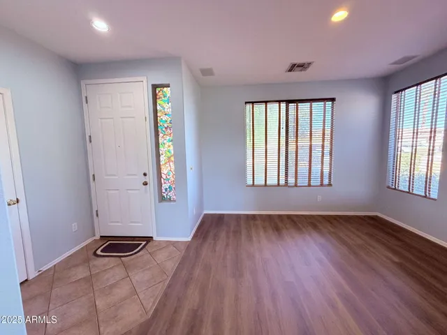 an empty room with window and wooden floor
