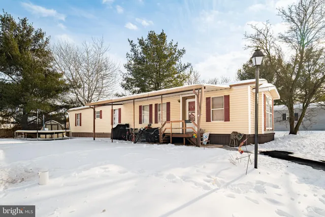 a view of a house with a yard covered in snow