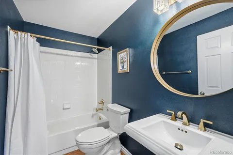 a bathroom with a sink and mirror with toilet