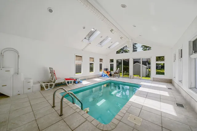 a view of a house with swimming pool and furniture