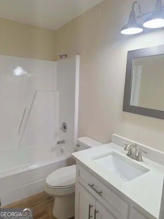 a bathroom with a granite countertop sink a toilet and a mirror