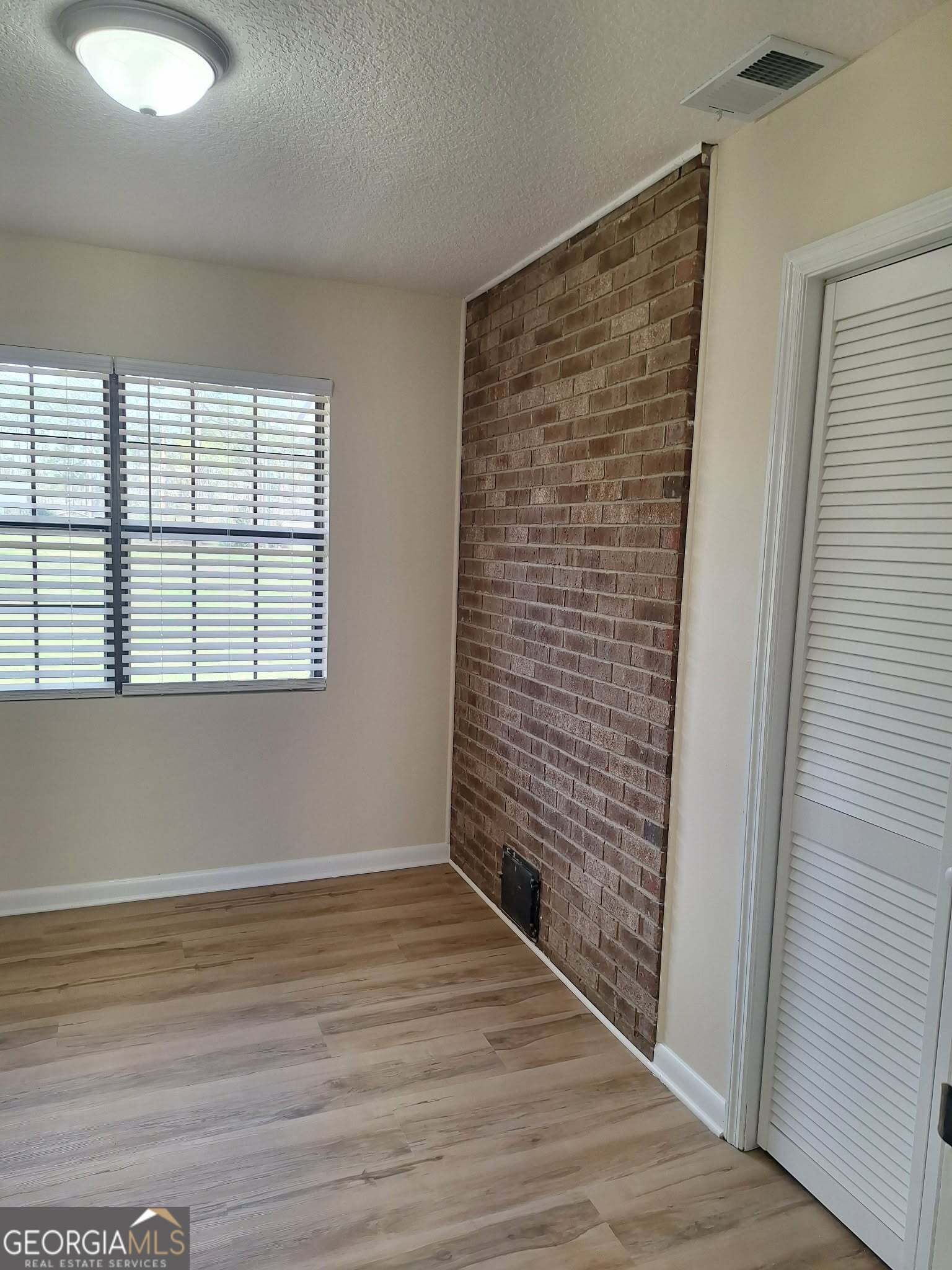 249 Satilla Church Road Baxley, GA 31513 - Photo 12 of 26 a view of an empty room with wooden floor and a window
