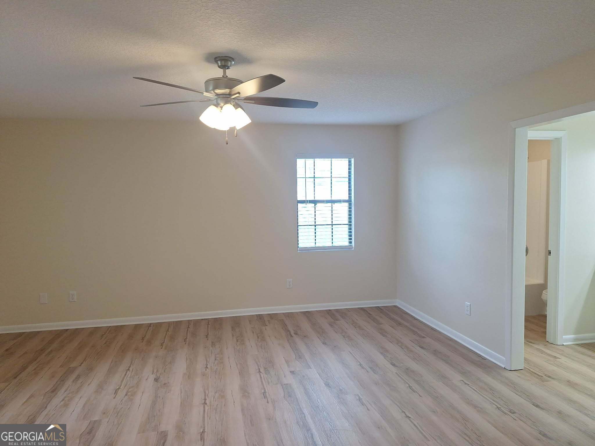 249 Satilla Church Road Baxley, GA 31513 - Photo 13 of 26 a view of empty room with wooden floor and fan