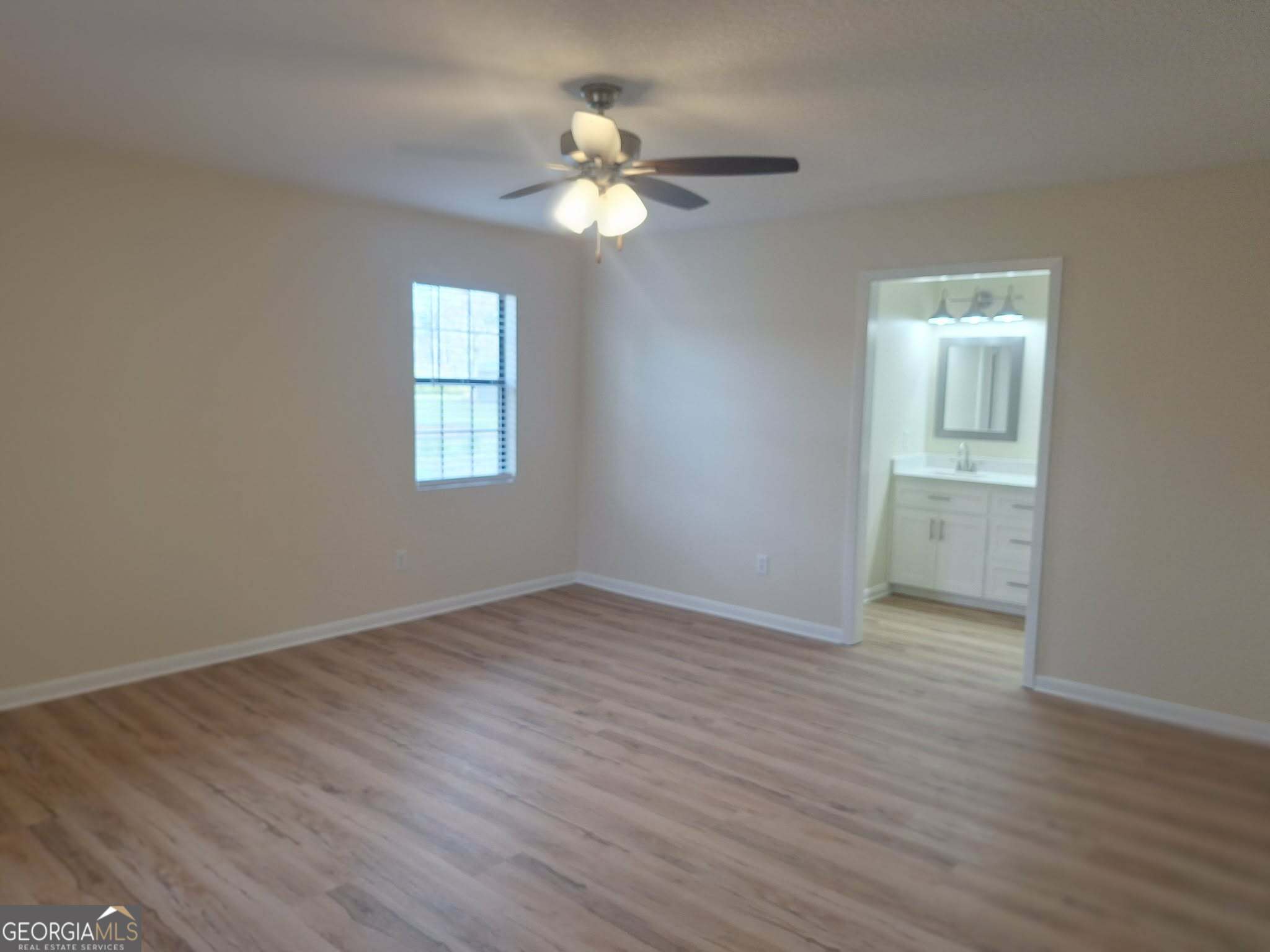 249 Satilla Church Road Baxley, GA 31513 - Photo 14 of 26 a view of an empty room with wooden floor and a window
