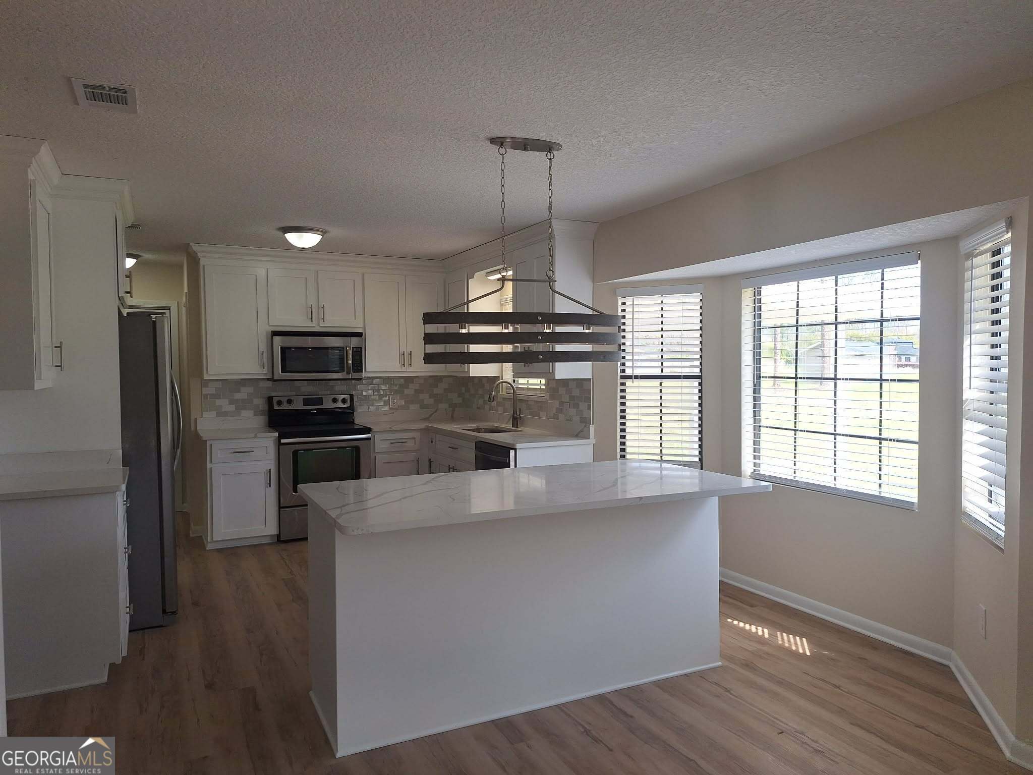 249 Satilla Church Road Baxley, GA 31513 - Photo 3 of 26 a kitchen with stainless steel appliances granite countertop a stove a refrigerator and a sink